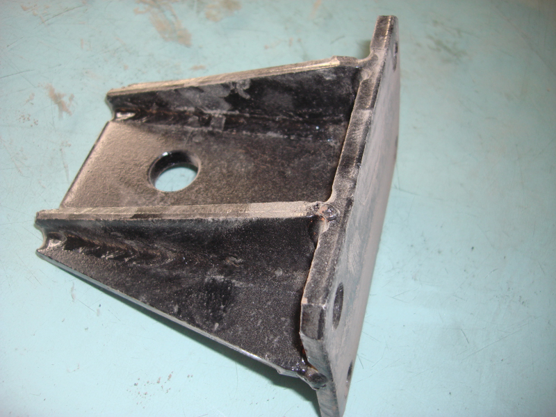 D The upper left bracket on the front suspension of the engine